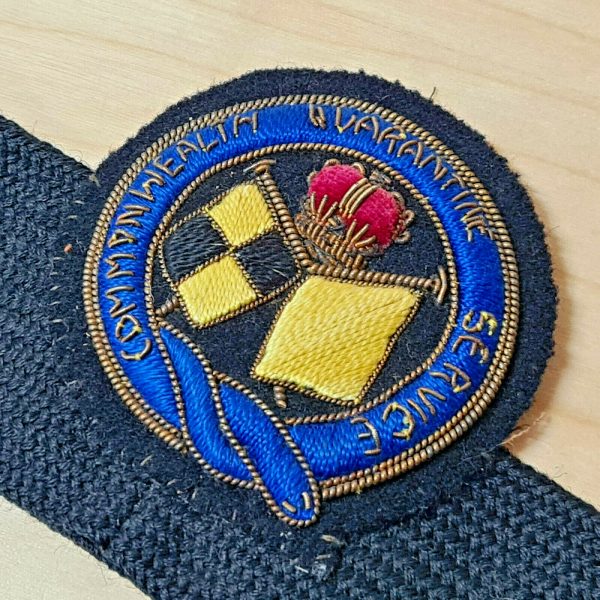 1950's ERA AUSTRALIAN COMMONWEALTH QUARANTINE SERVICE UNIFORM CAP BADGE ON BAND