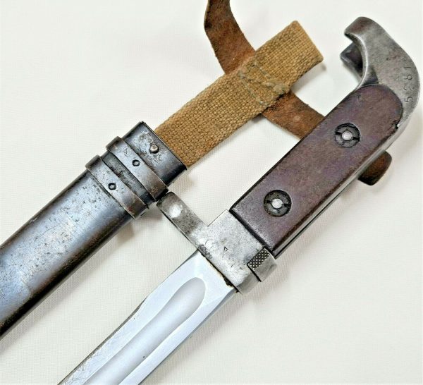 Offered is an original Russian AK-47 bayonet & scabbard. Early type bayonet, featuring wooden grips, curved metal pommel, number stamped 5281, with metal muzzle ring attachment guard. 20cm long with metal blade, showing field sharpening marks to edge, very good overall, which fits nicely into the darkened metal scabbard, which retains the canvas frog and leather fastening straps. Overall length 32.5cm. Service wear and some age to this piece, but good condition overall. This bayonet is from the Rhodesian army collection we are currently selling, so as with many of the other captured pieces in there, I would be certain this is one of those 'souvenired' combat pieces.